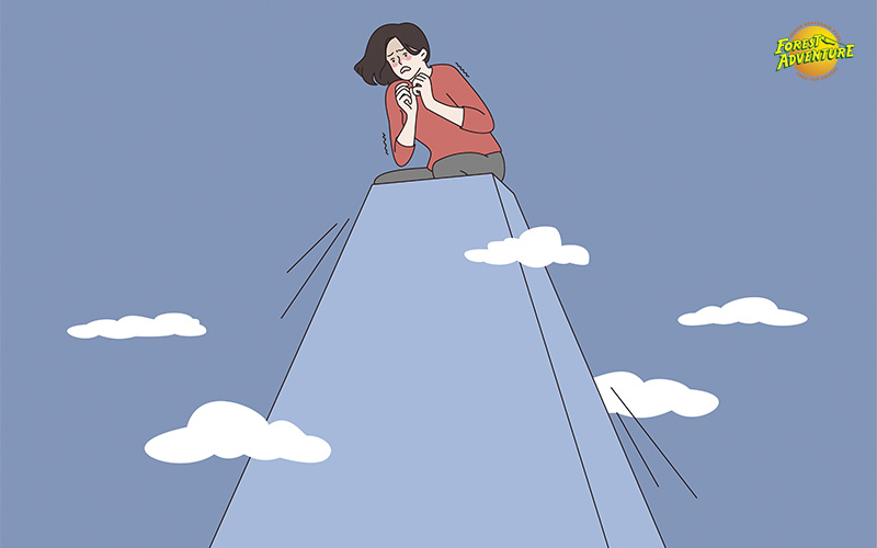 A woman sitting anxiously on a mountain peak with clouds around and a Forest Adventure logo in the corner